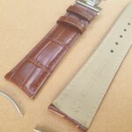 curved lug black Alligator pattern leather watch strap with deployant clasp up close showing curved lug spring bars