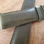 CLOSE UP OF GREEN LEATHER OF WATCH STRAP