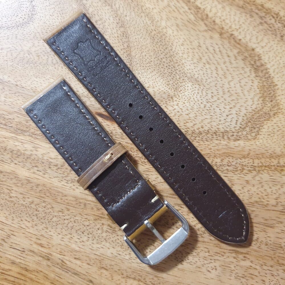 underside of a leather watch strap with silver buckle