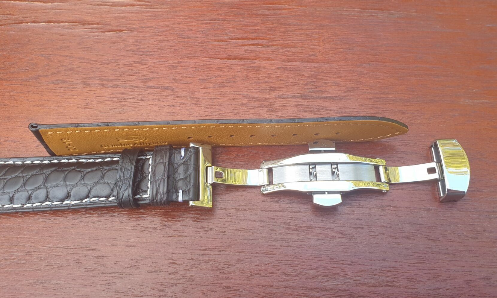 alligator leather strap laying on side showing thickness